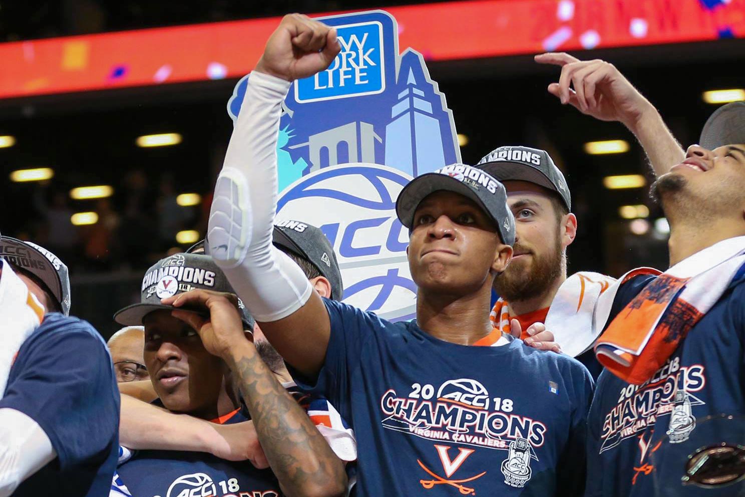 Basketball team celebrates on stage after winning ACC championship