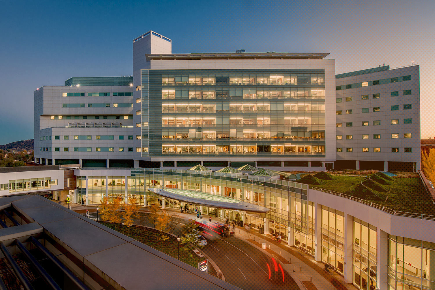 Aerial view of the UVA Hospital at dusk with lights on