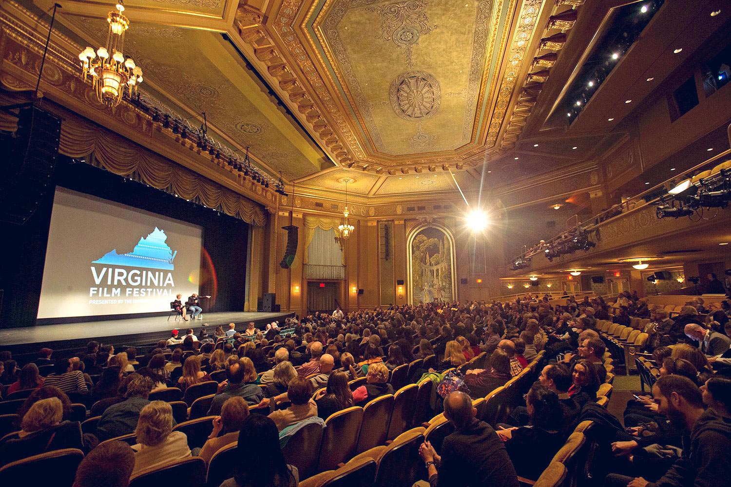 Theatre filled with people looking at speakers on stage during the Virginia Film Festival