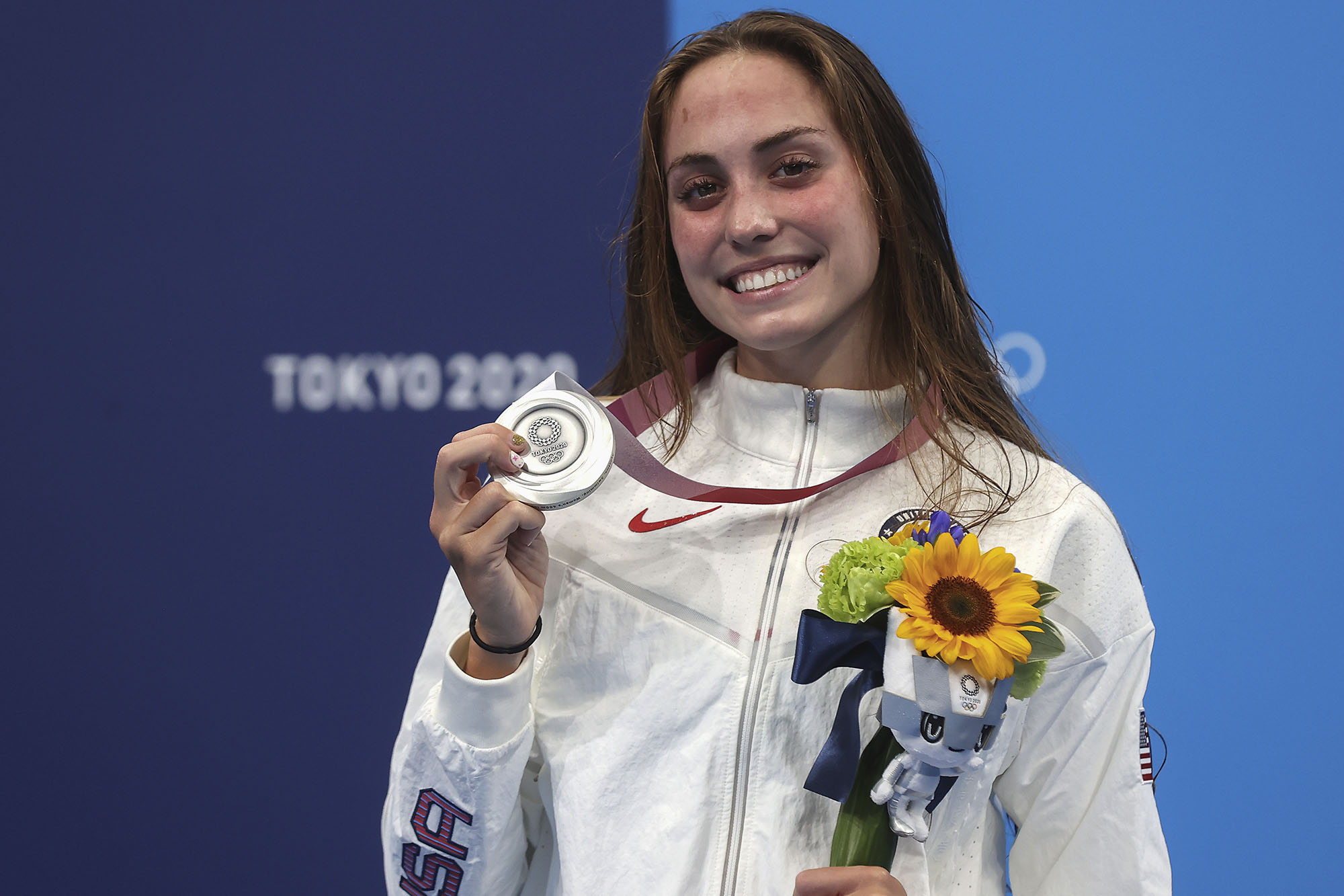 Emma Weyant holds silver medal and flowers and smiles to the camera