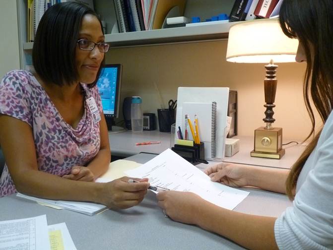 Ishan Williams talking to a nursing student in her office