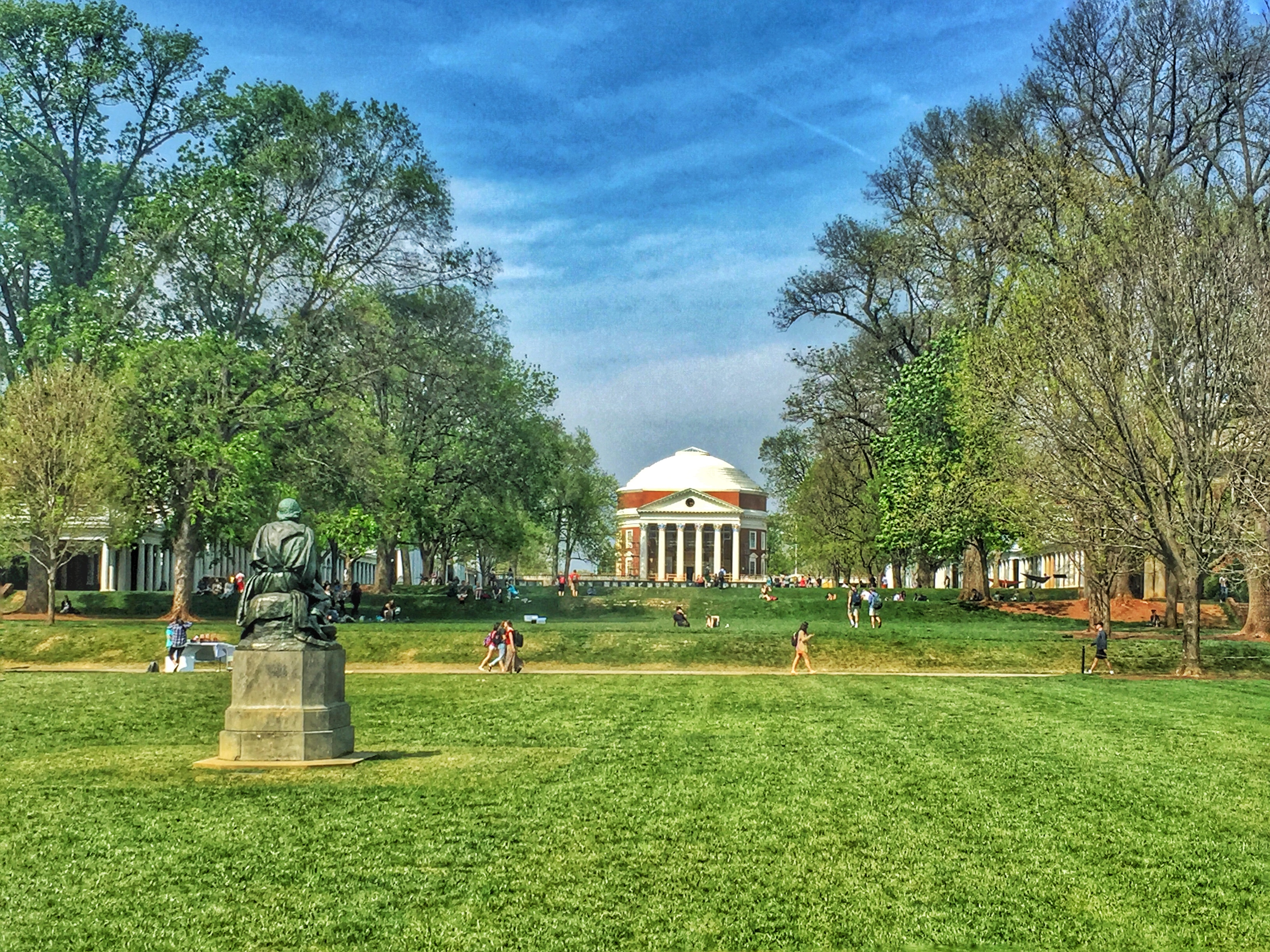 The Rotunda in the distance as students walk on the lawns sidewalks to and from classes