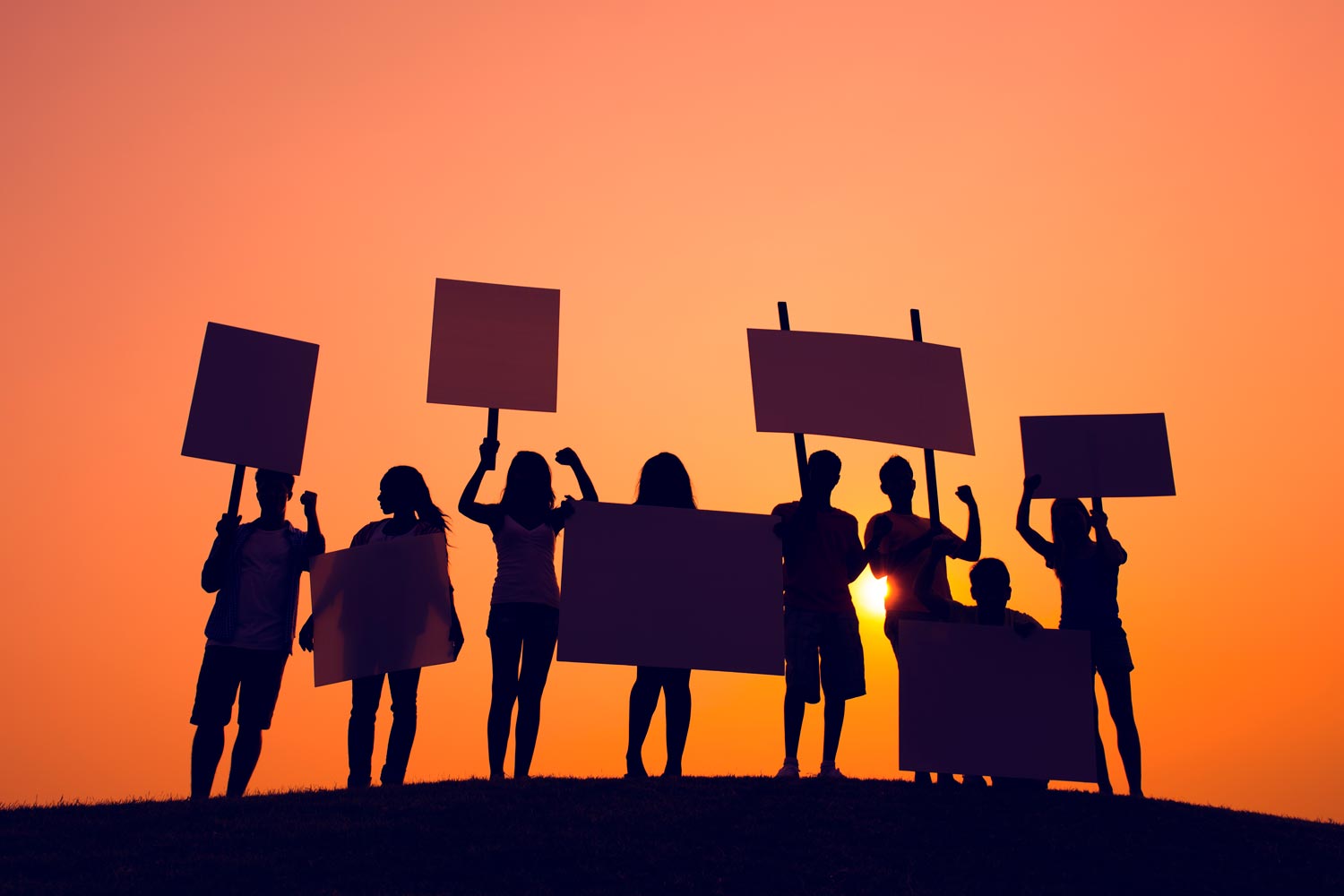 Silhouettes of youth holding signs