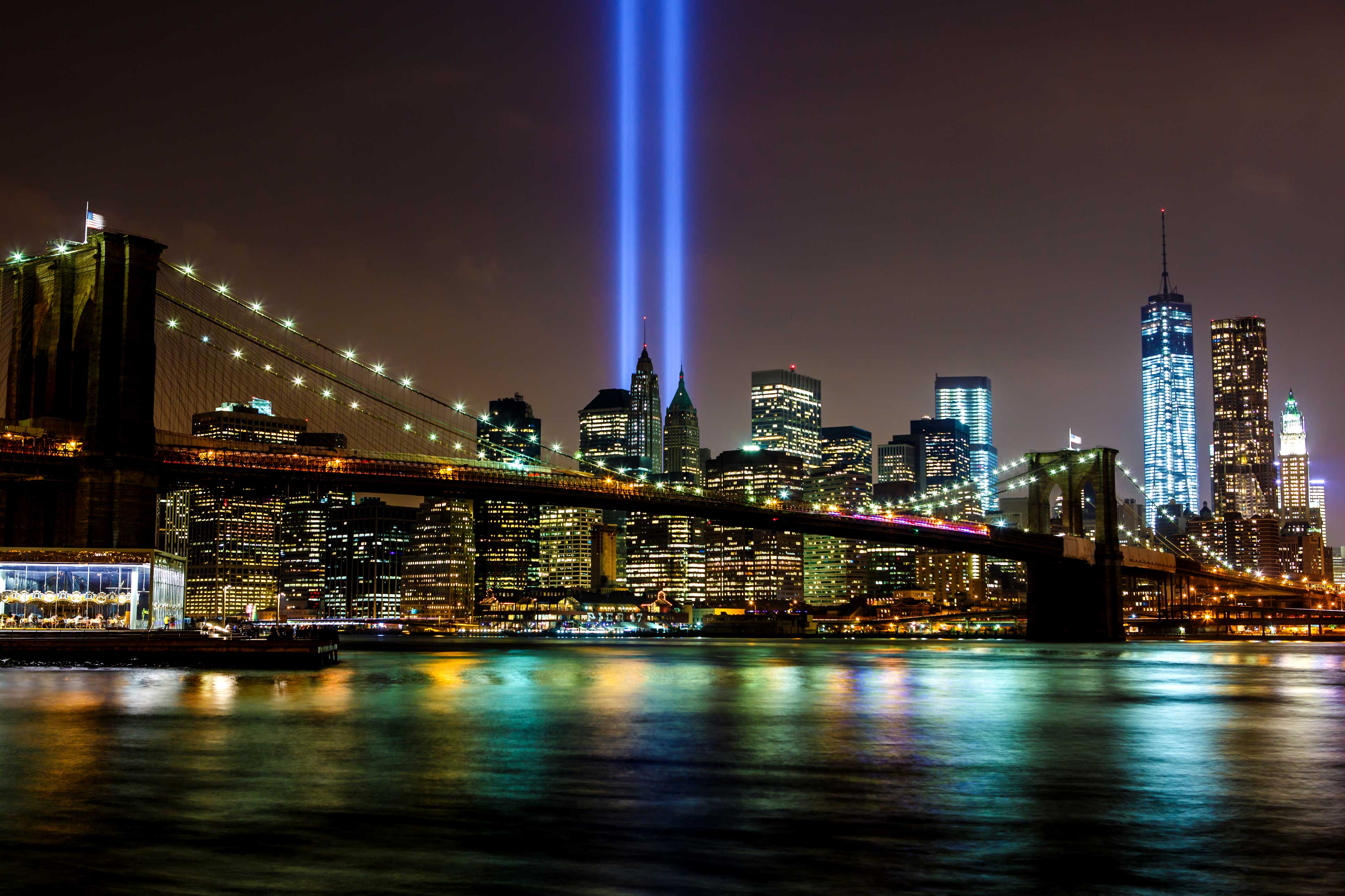 Two blue lights shine out of the New York Cityscape into the air as a memorial to 9/11