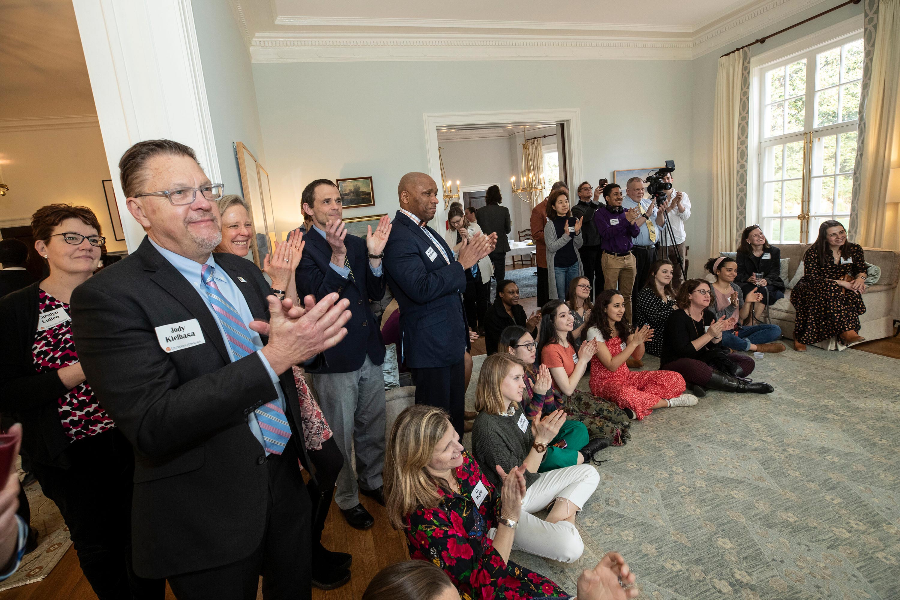 Group of people clapping in a room after a poem was read