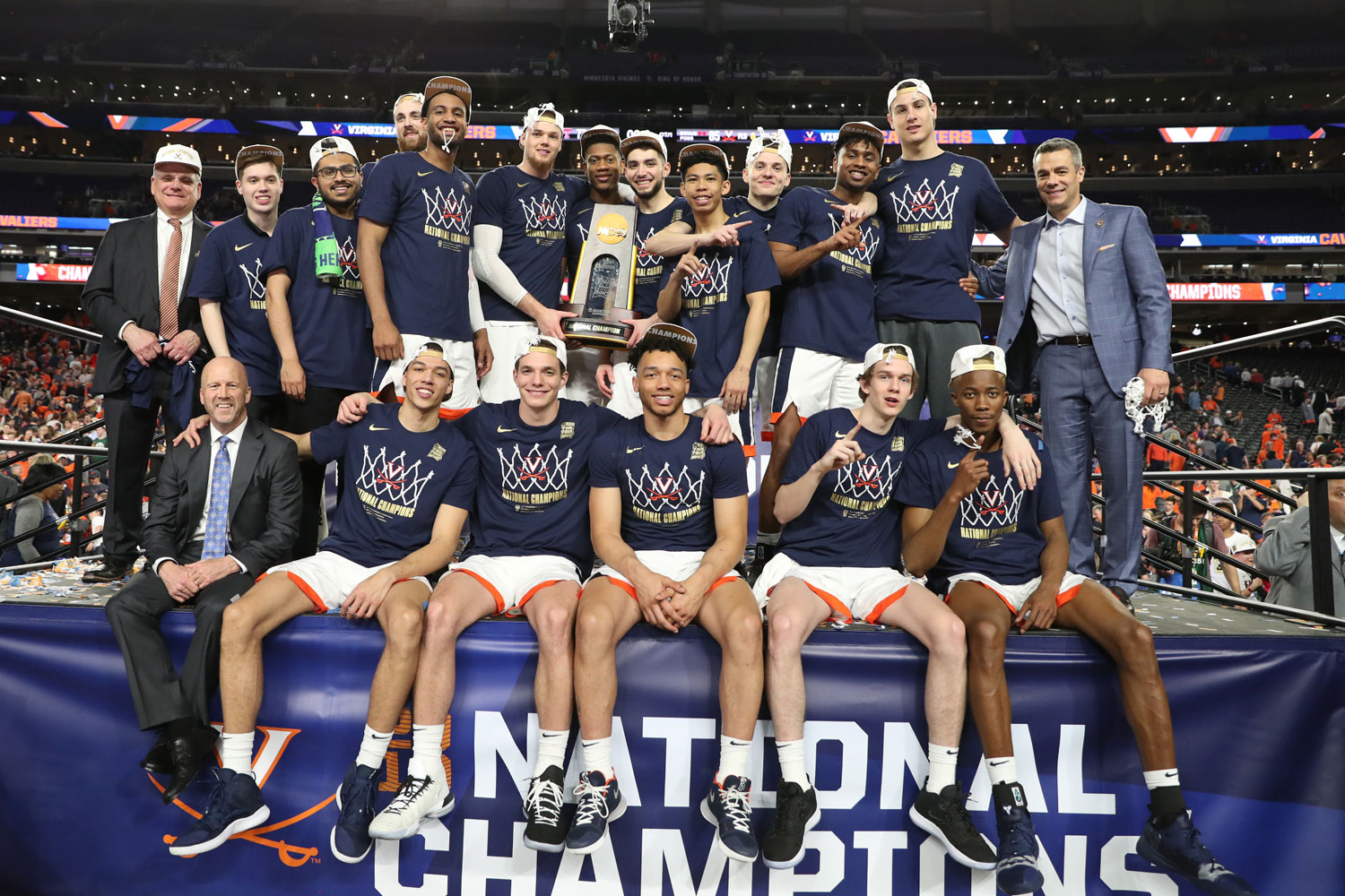 UVA basketball team on stage holding the NCAA trophy