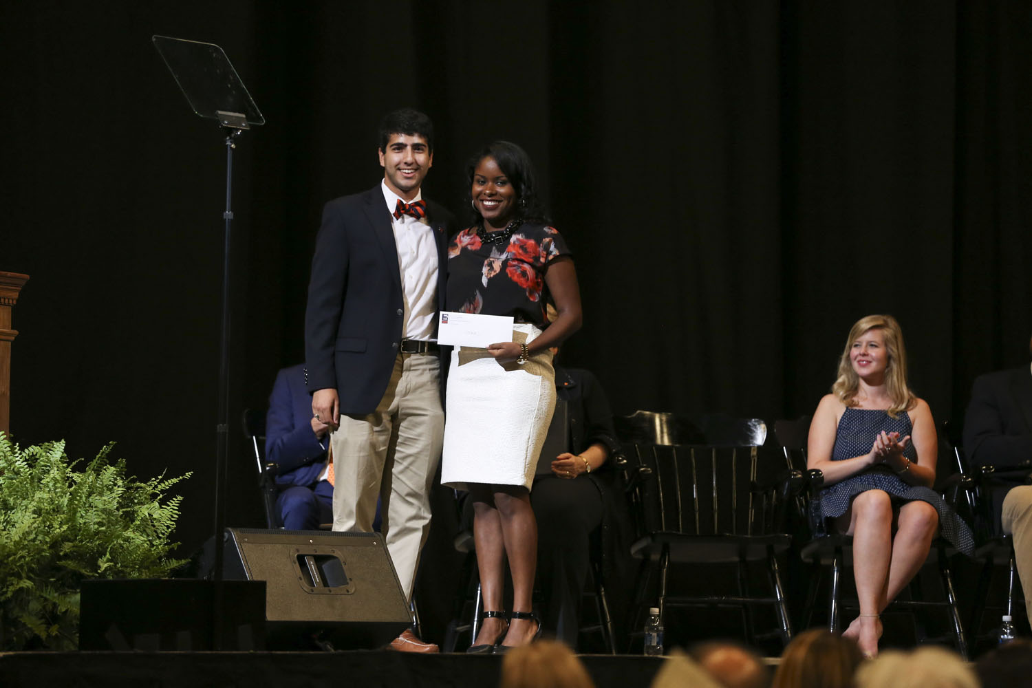 Tamara Saint-Surin, right, stands with D. Naveed Tavakol on stage for a picture