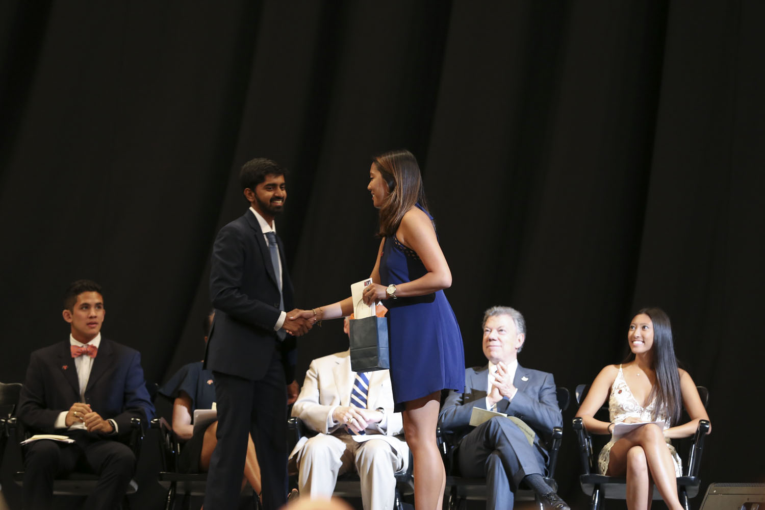 Ngan K. Pham, right, shakes Shreyas R. Hariharan, lefts, hand on stage