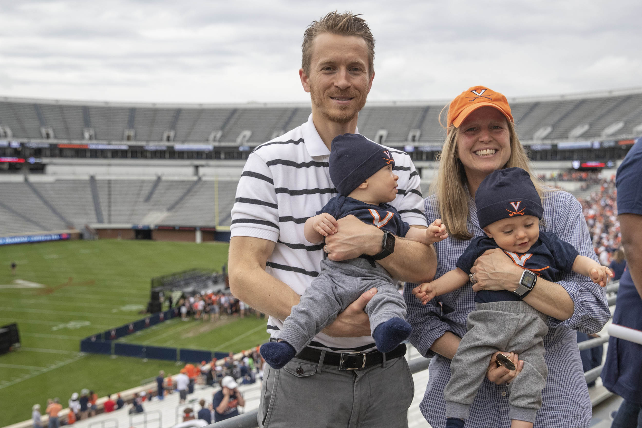 Twins William and James being held by their parents in Scott Stadium