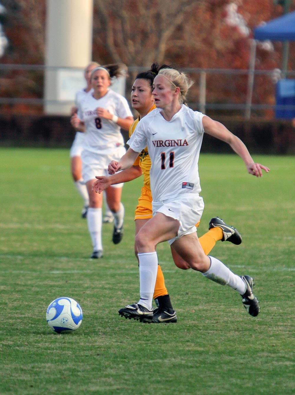 Becky Sauerbrunn running against opponent to get to the soccer ball during a game