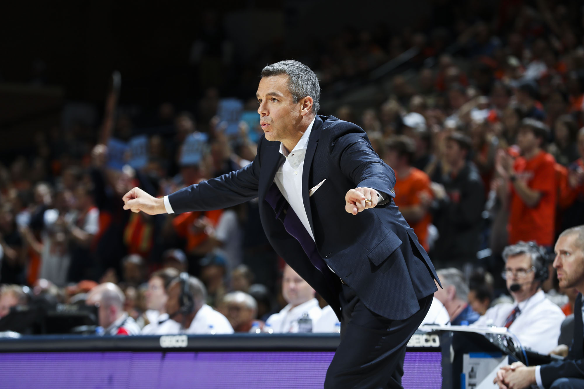 Tony Bennett coaching during a game with both arms out to the side