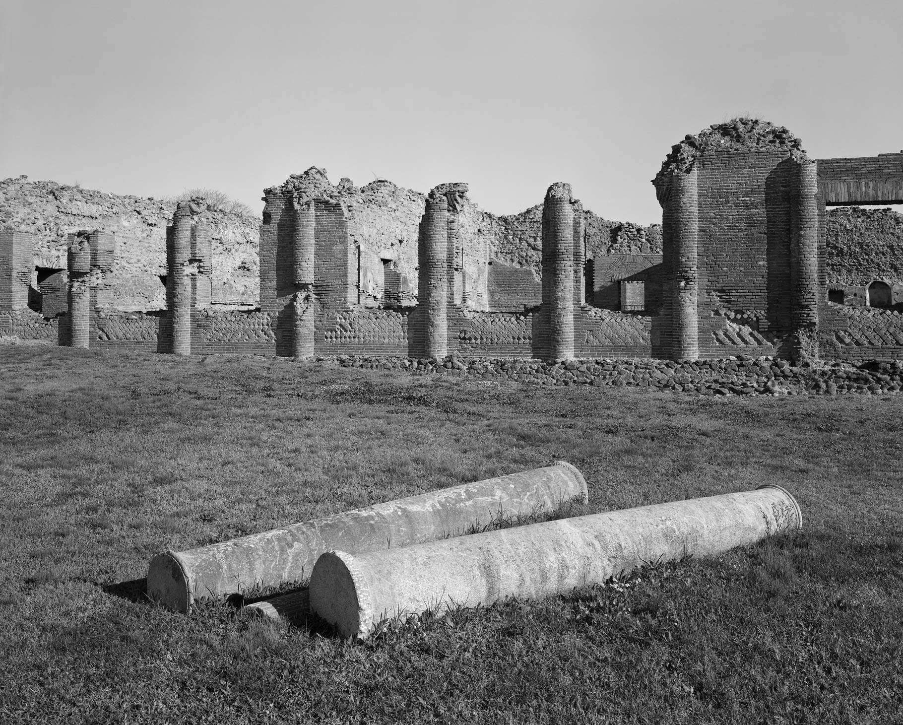Broken walls and pillars of a building in pompeii, black and white image