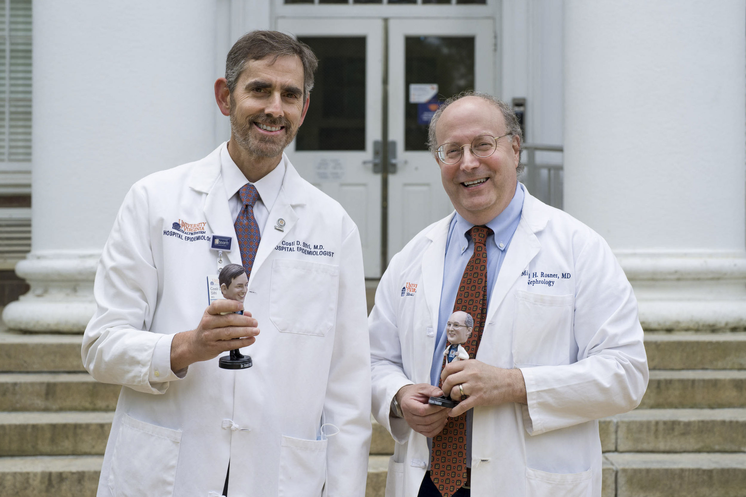 Dr. Costi Sifri, left, and Dr. Mitch Rosner, right, hold bobble heads of themselves