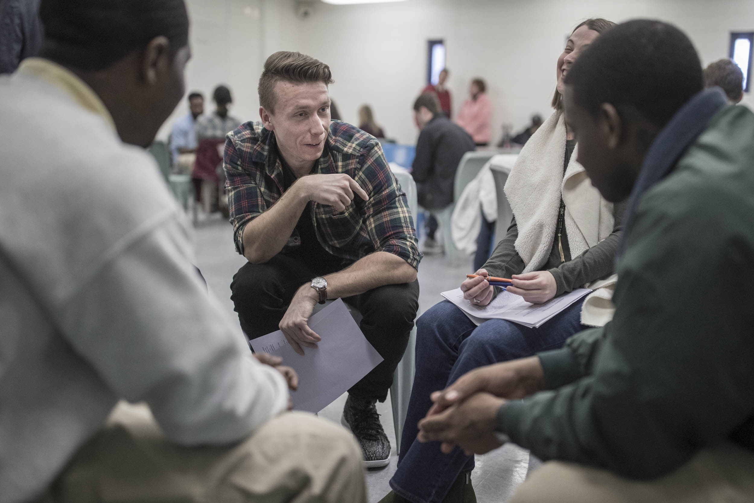 Man talking to a group of prisoners in a circle