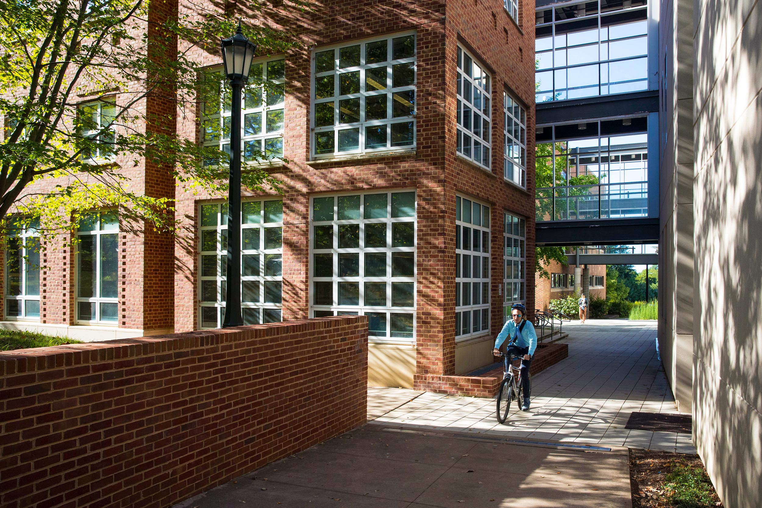 Person reading a bike on the sidewalk at the Chemical Engineering building