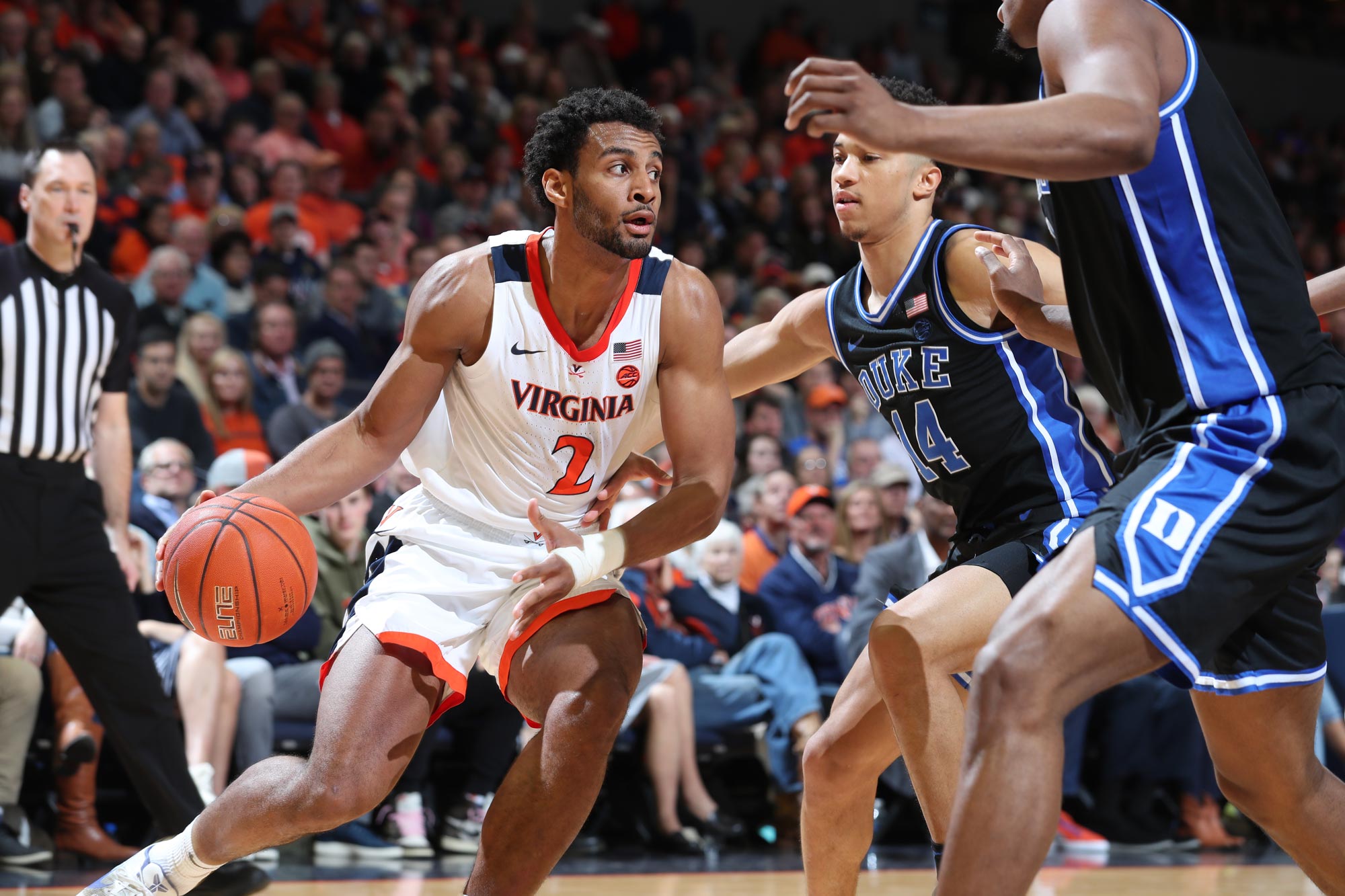 Braxton Key dribbling the basketball between two defenders