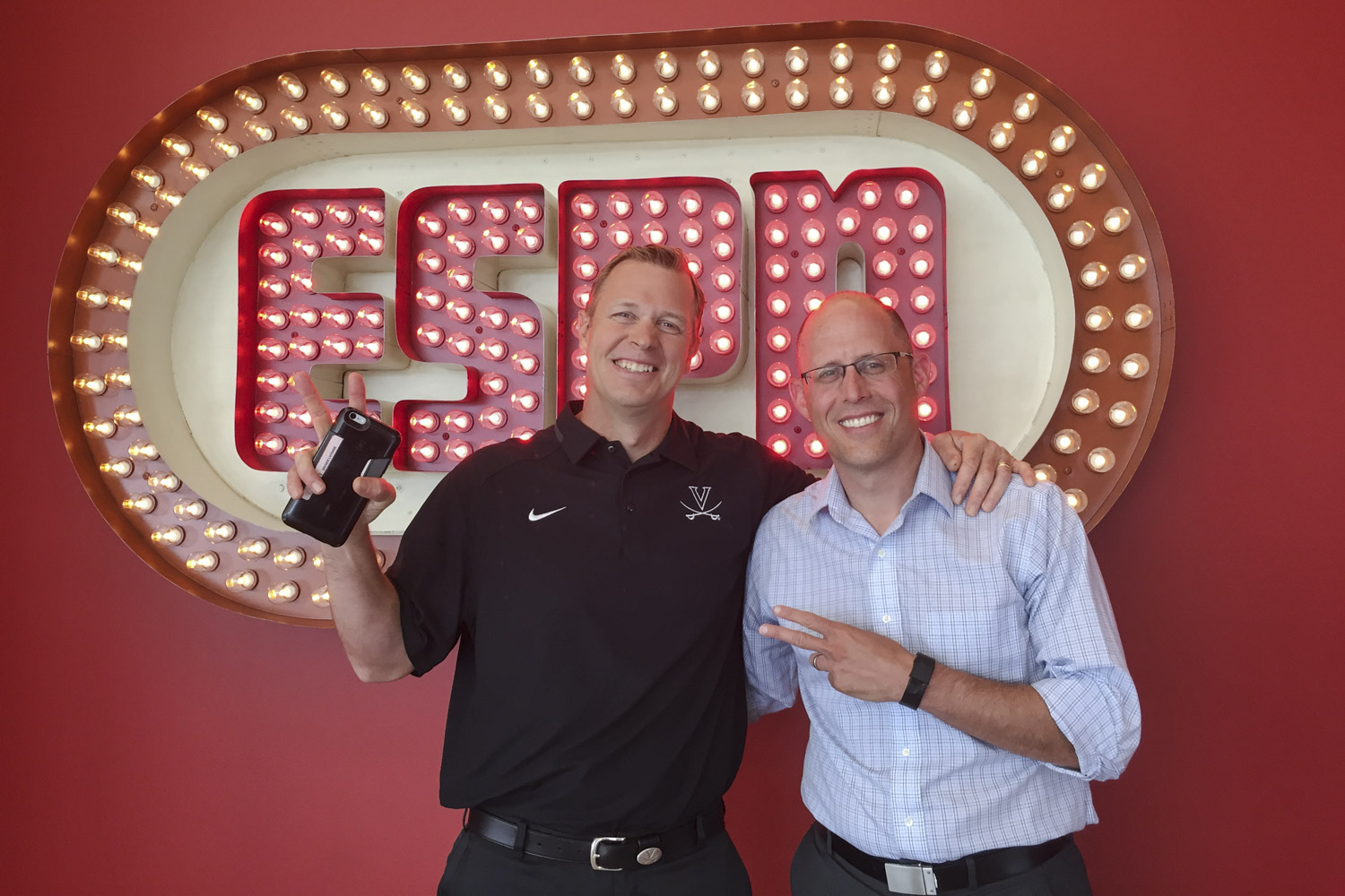 Bronco Mendenhall and Hofheimer posing together for a picture in front of a lighted ESPN sign