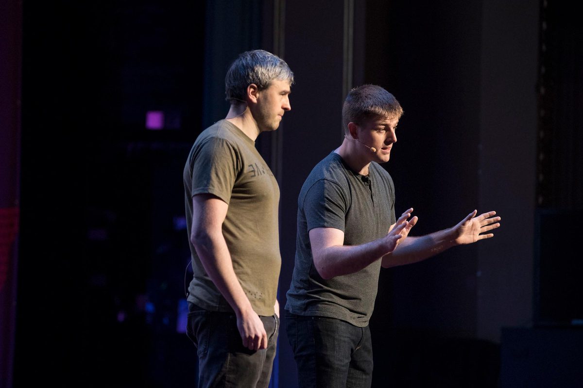 Bryan, right, and his brother Bradford, left speaking together on a stage