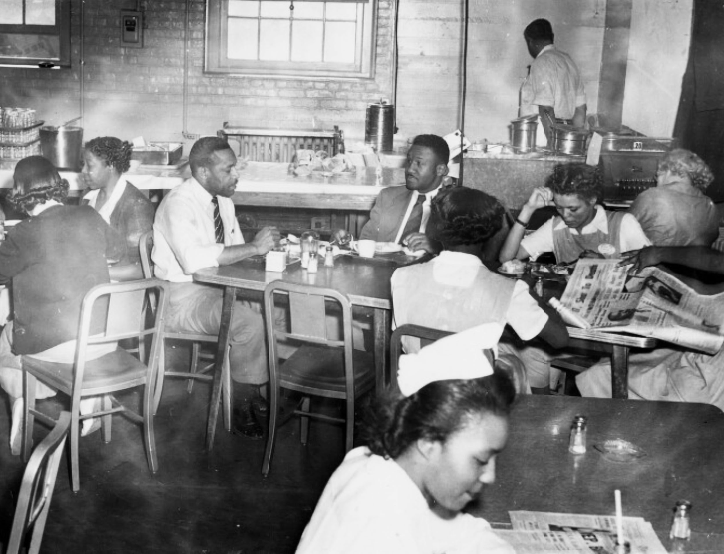 African American men and women eating and talking in a segregated cafeteria 