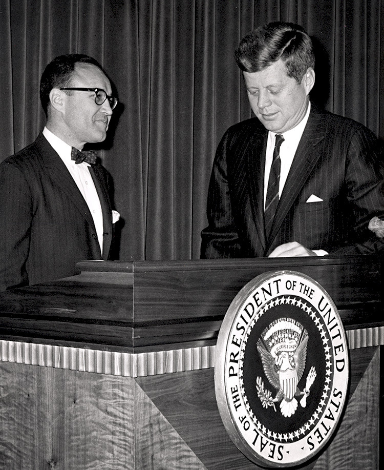 Caplin  and Kennedy at a podium black and white image