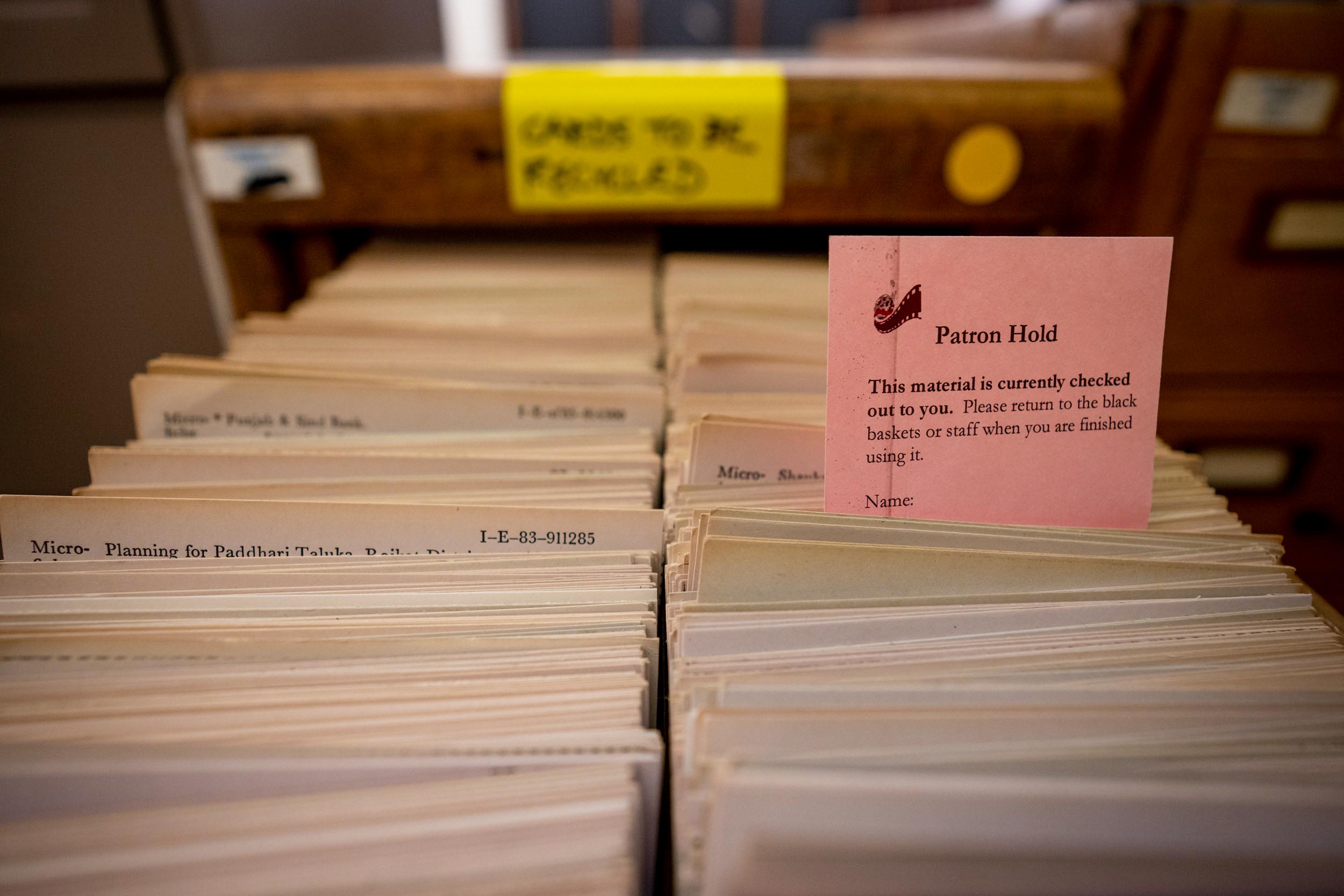 A drawer filled with book cards with a pink that says Parton Hold