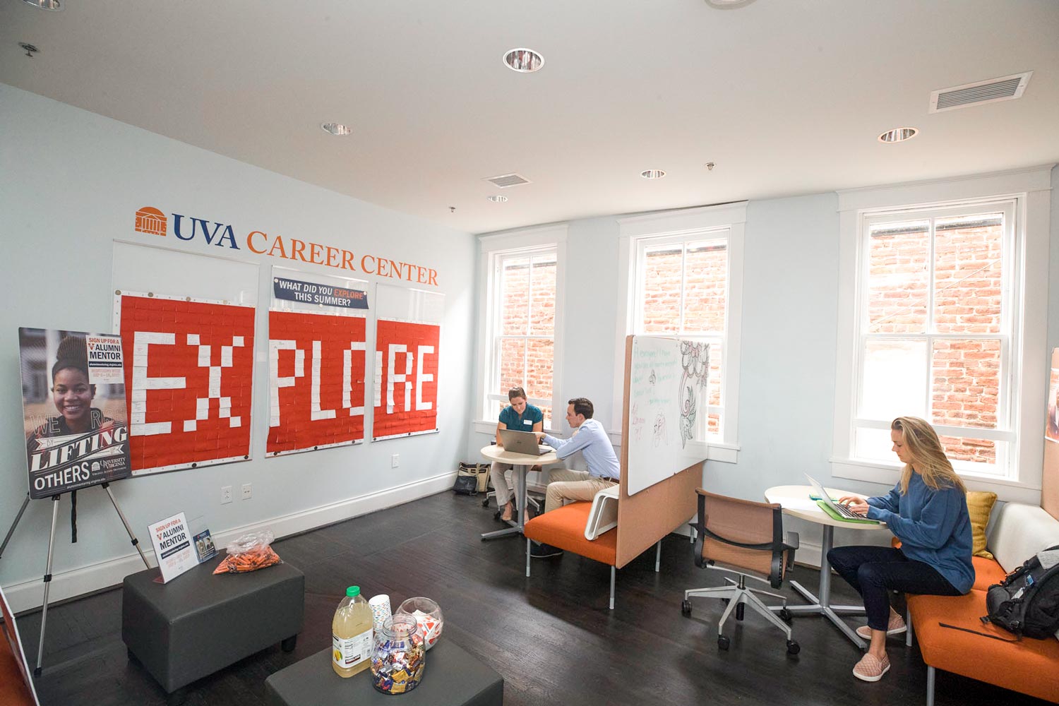 People sitting at tables in the Career Center helping each other