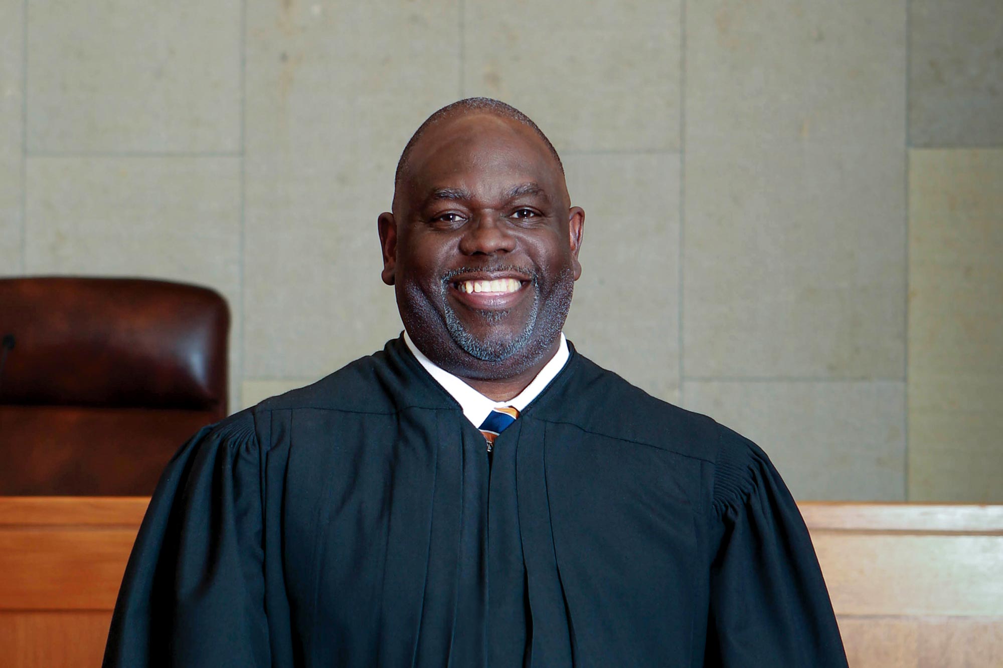 Judge Brings stand in front of his bench and smiles at the camera