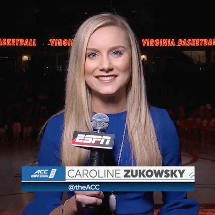 Caroline Zukowsky holding an ESPN microphone looking into the camera