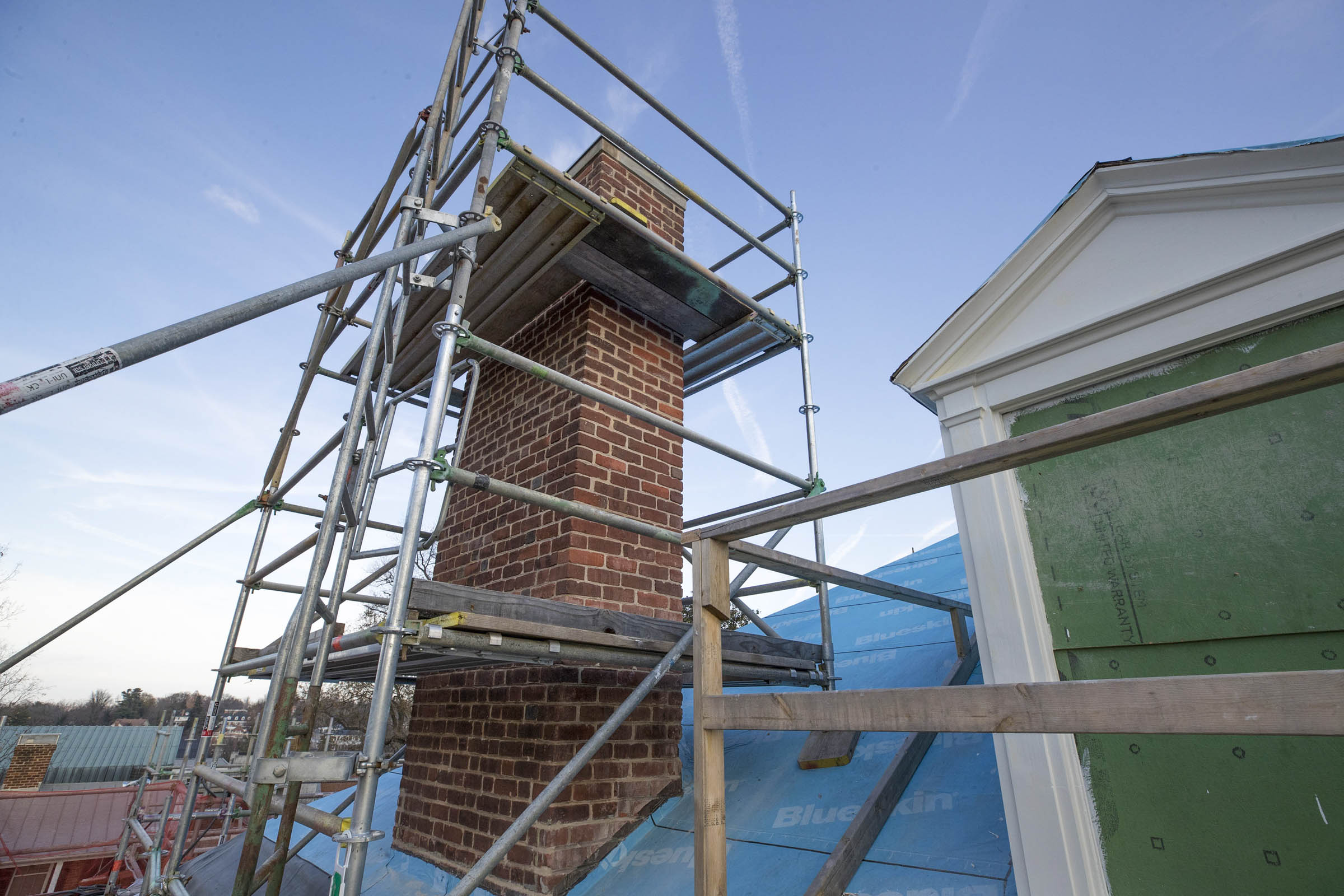 scaffolding around a brick chimney