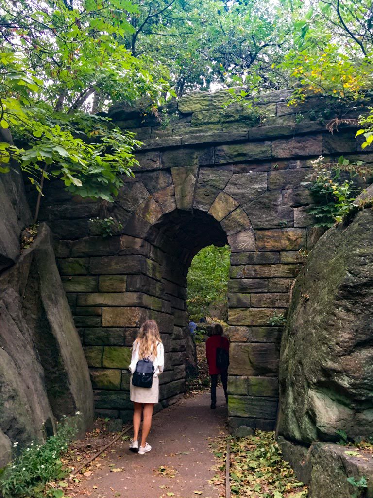 Students going through a Stone archway on a hike