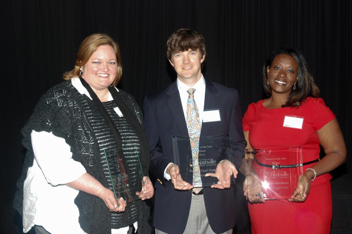 Chad Prather, middle, holds a glass award he won in Nashville