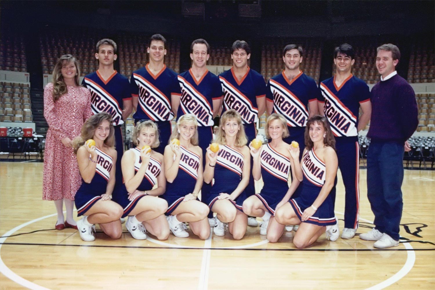 Craig Wood and his fellow cheerleaders for a team photo.  The women hold oranges