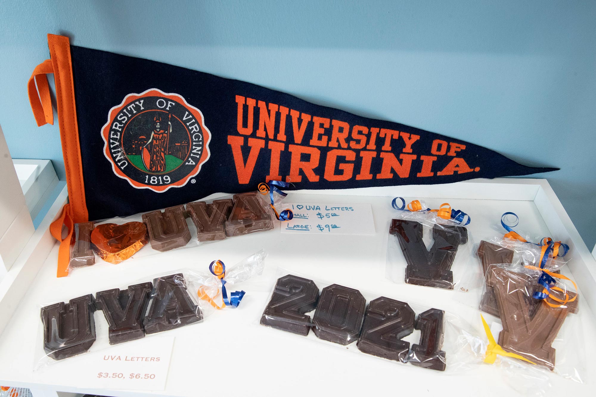 Chocolatesville Graduation chocolates.  Chocolates say: UVA, 2021, UVA V and displayed is a UVA pennant flag