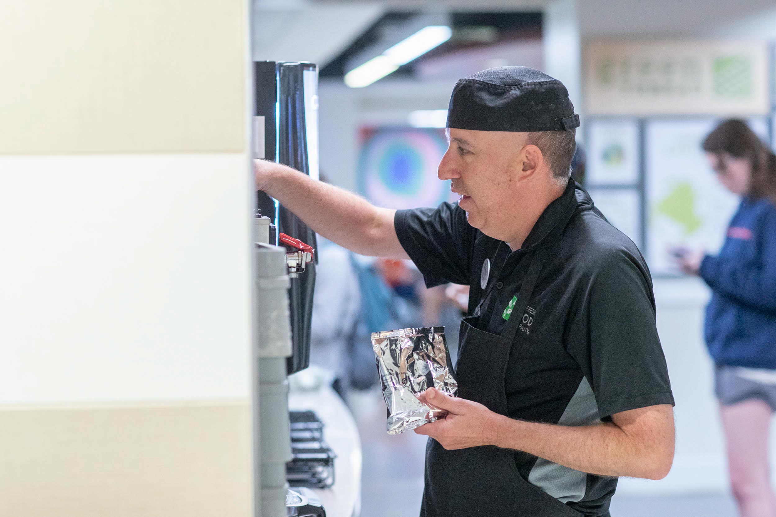 Chris Raupp filling up a coffee machine