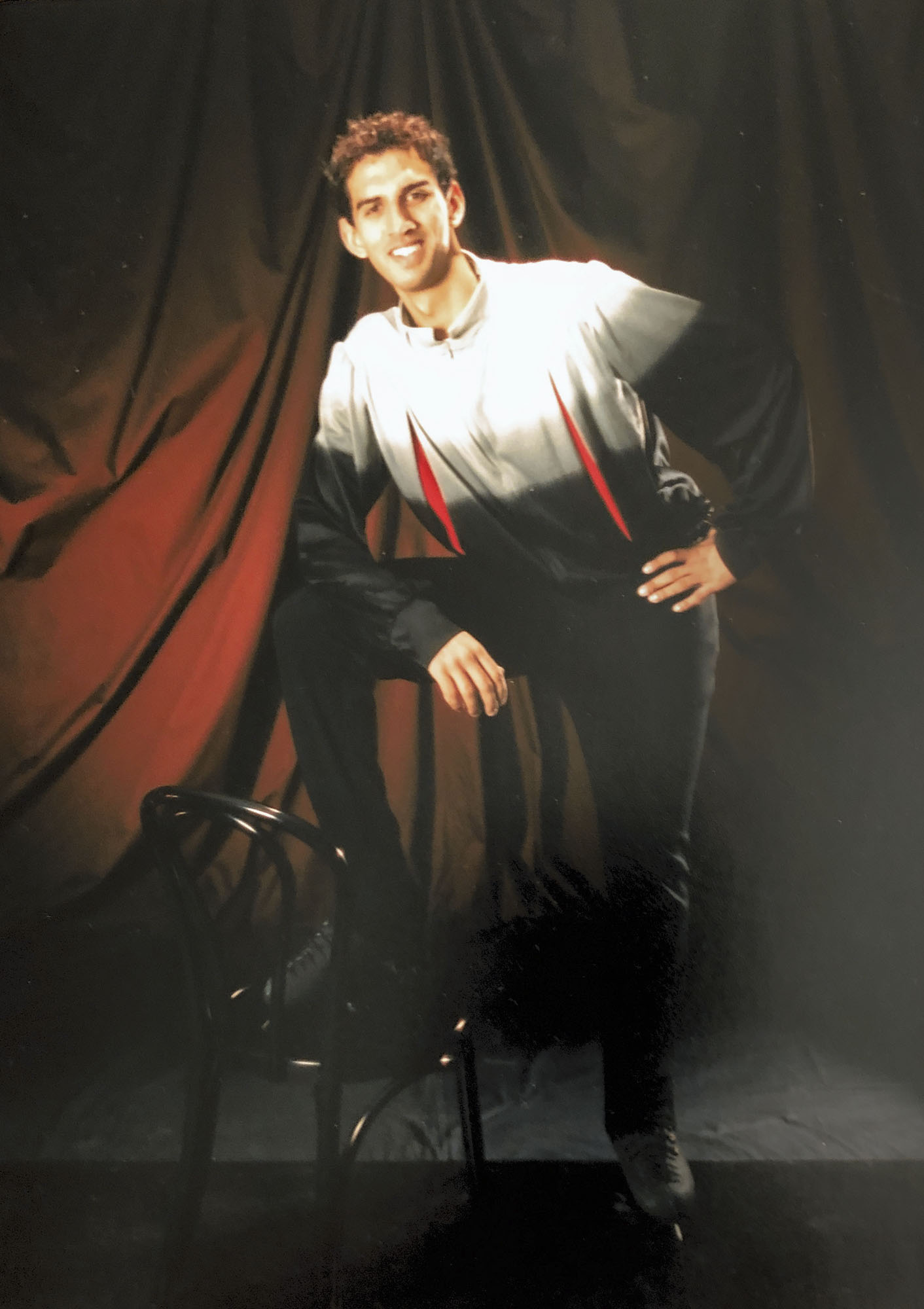 Christopher Ali standing with one leg on a chair posing for a picture