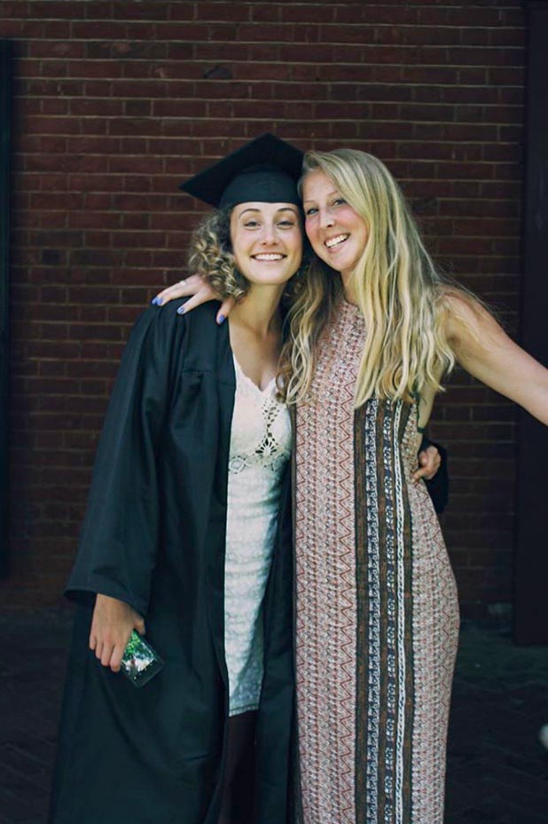 Claire Janek, left, and her older sister, Madison, right, pose together for a picture on graduation day
