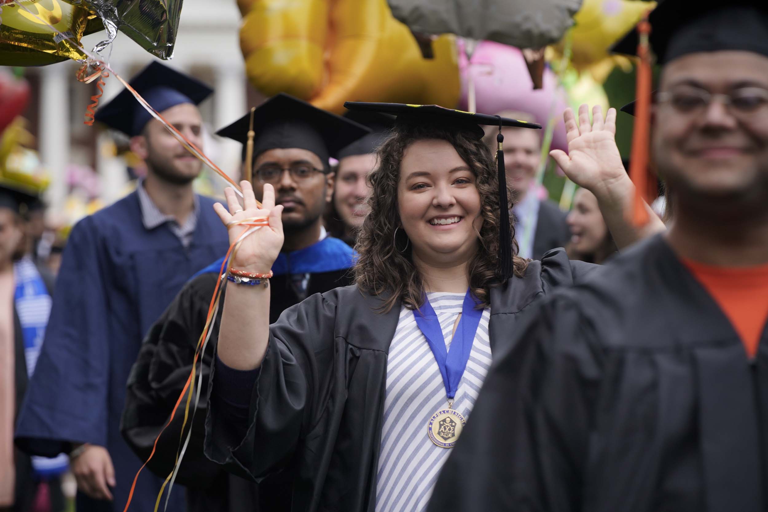 Graduates walking and waving