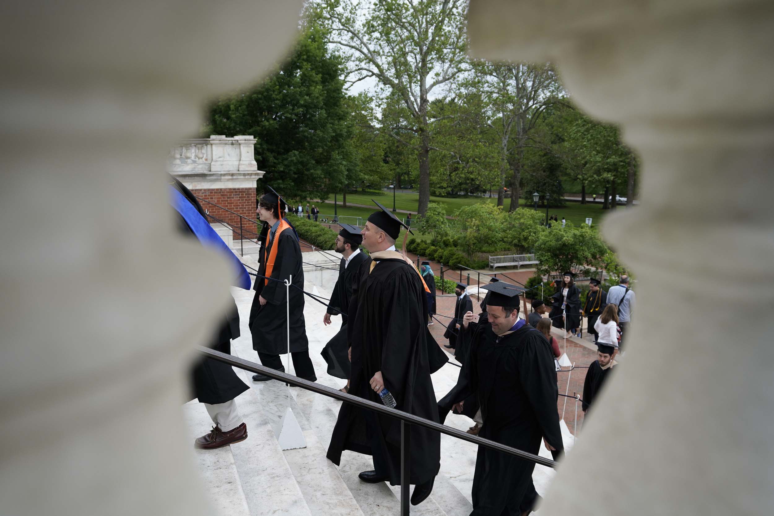 View of the graduates walking up steps taken between two columns