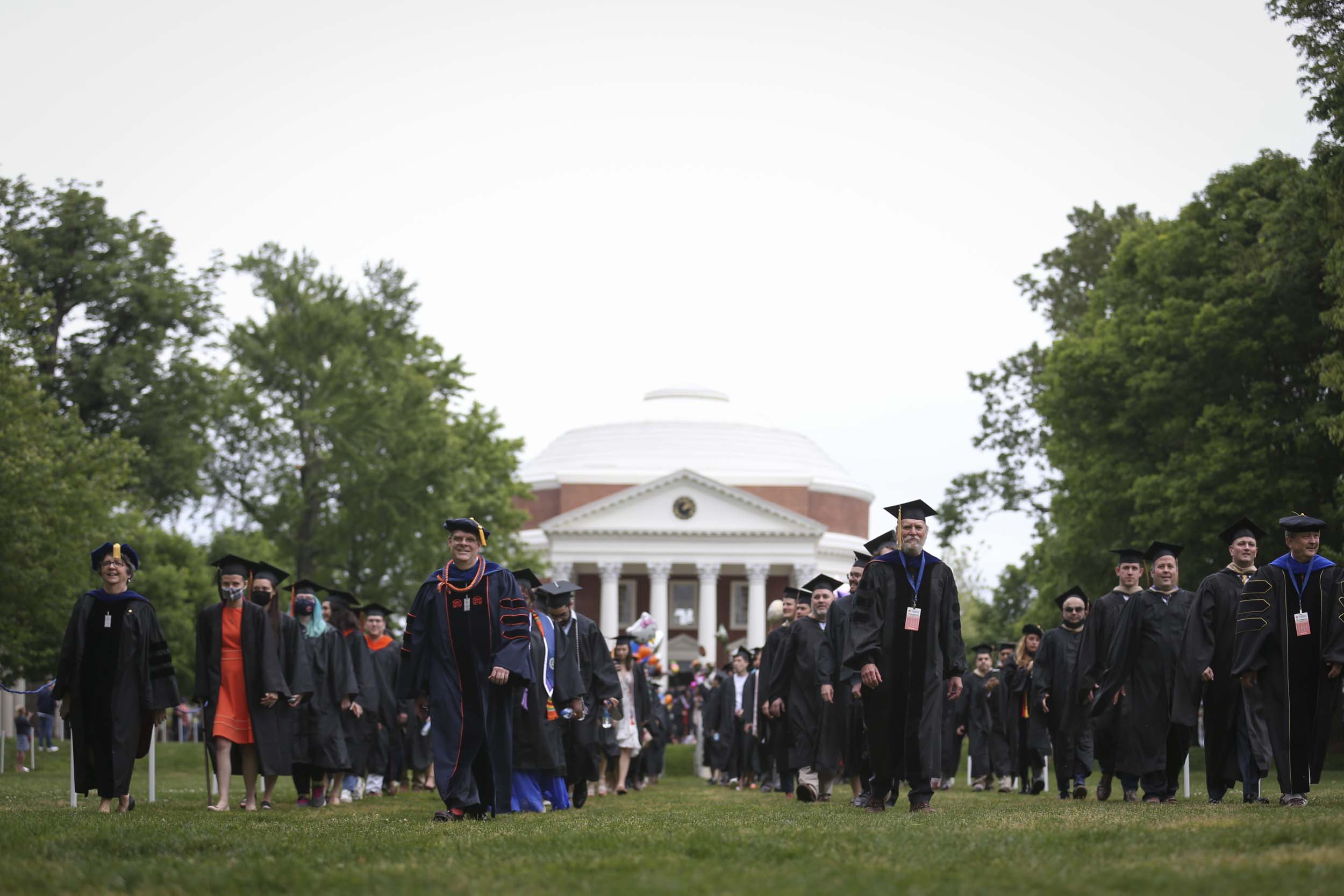 UVA faculty, Executive Leadership, and students walking across the Lawn from the Rotunda