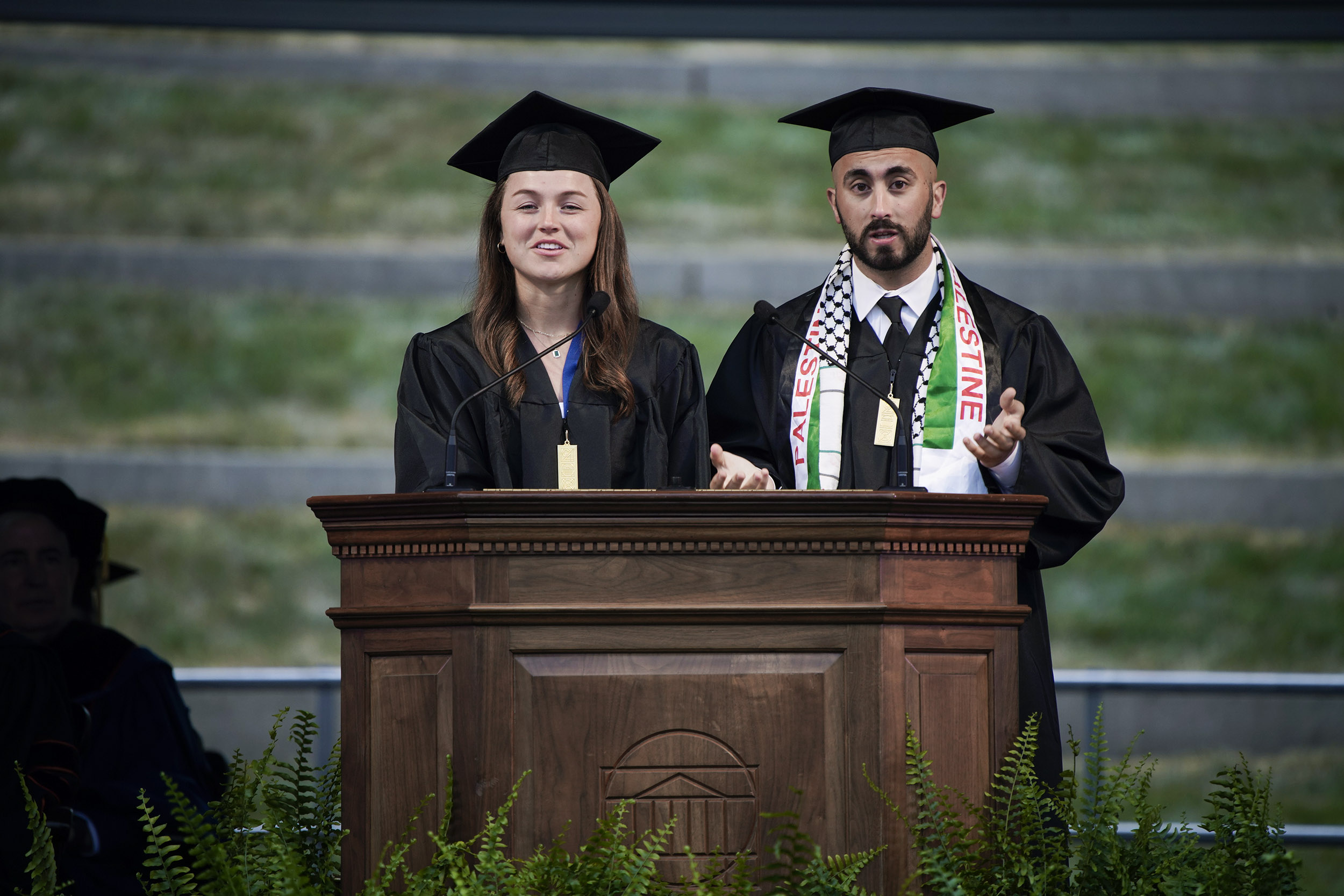 Omar Elhaj, right, and Ginny Brooks, left, stand at the podium giving a speech together