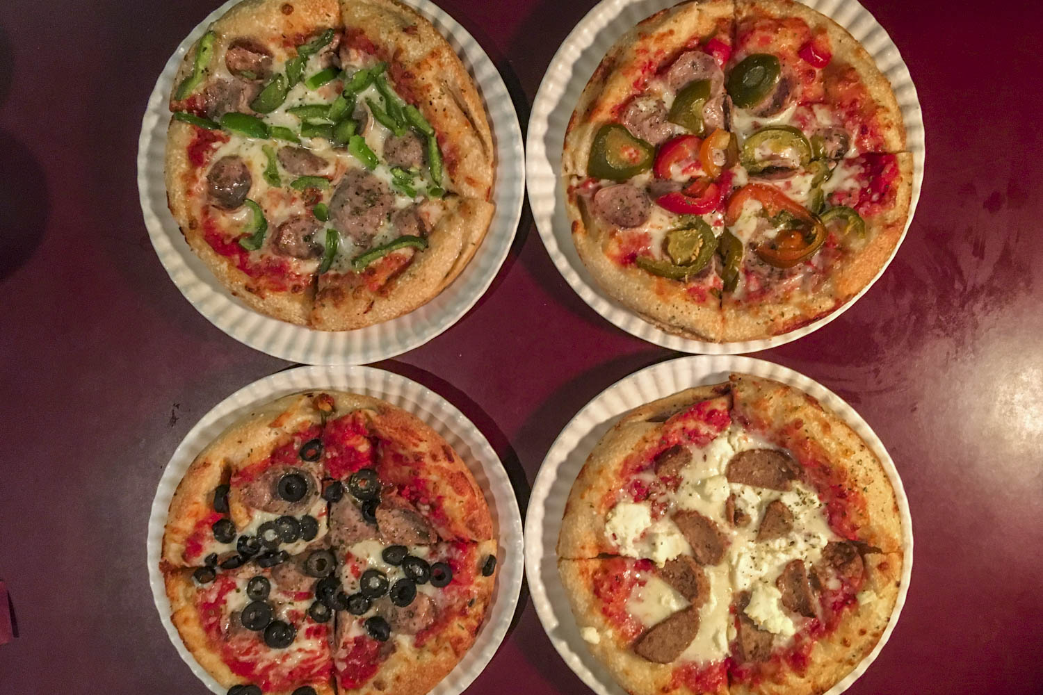 Various kinds of pizza on paper plates