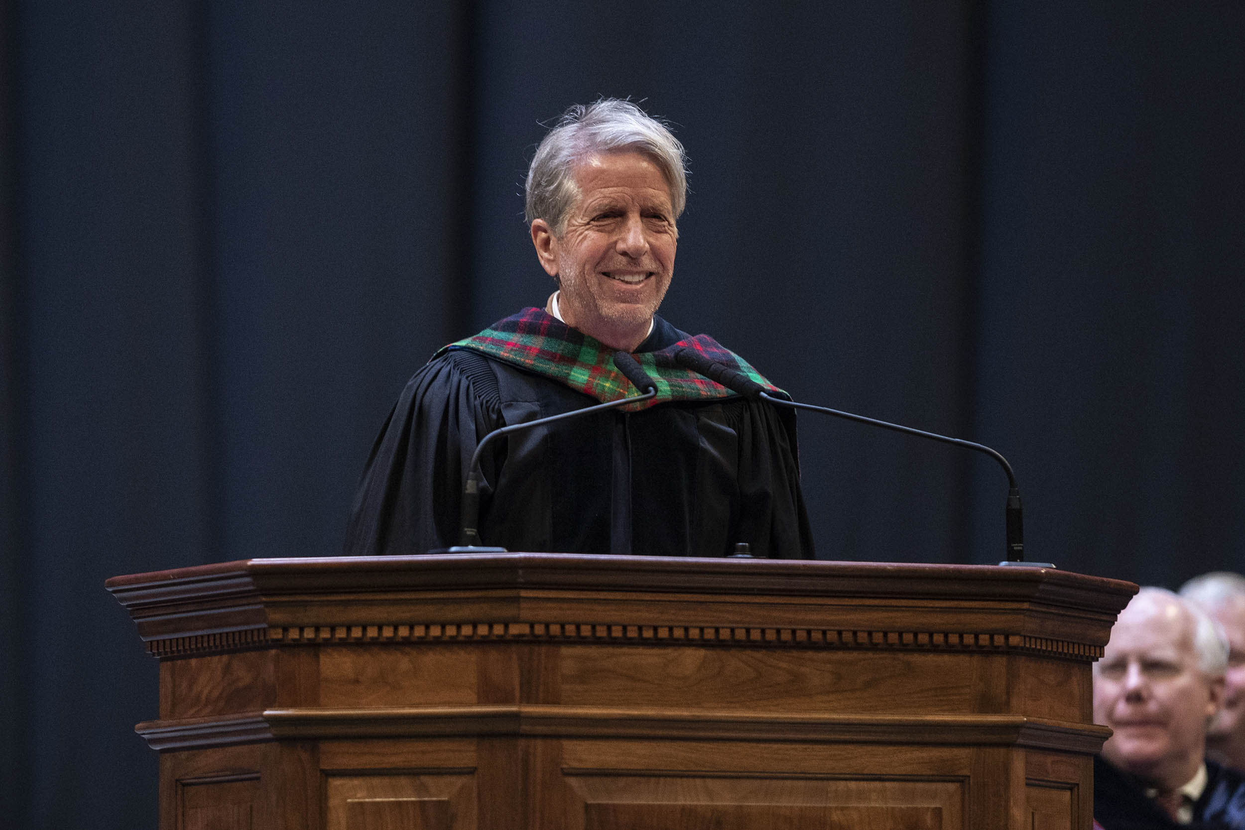 Charles A. Holt stands at a podium giving a speech