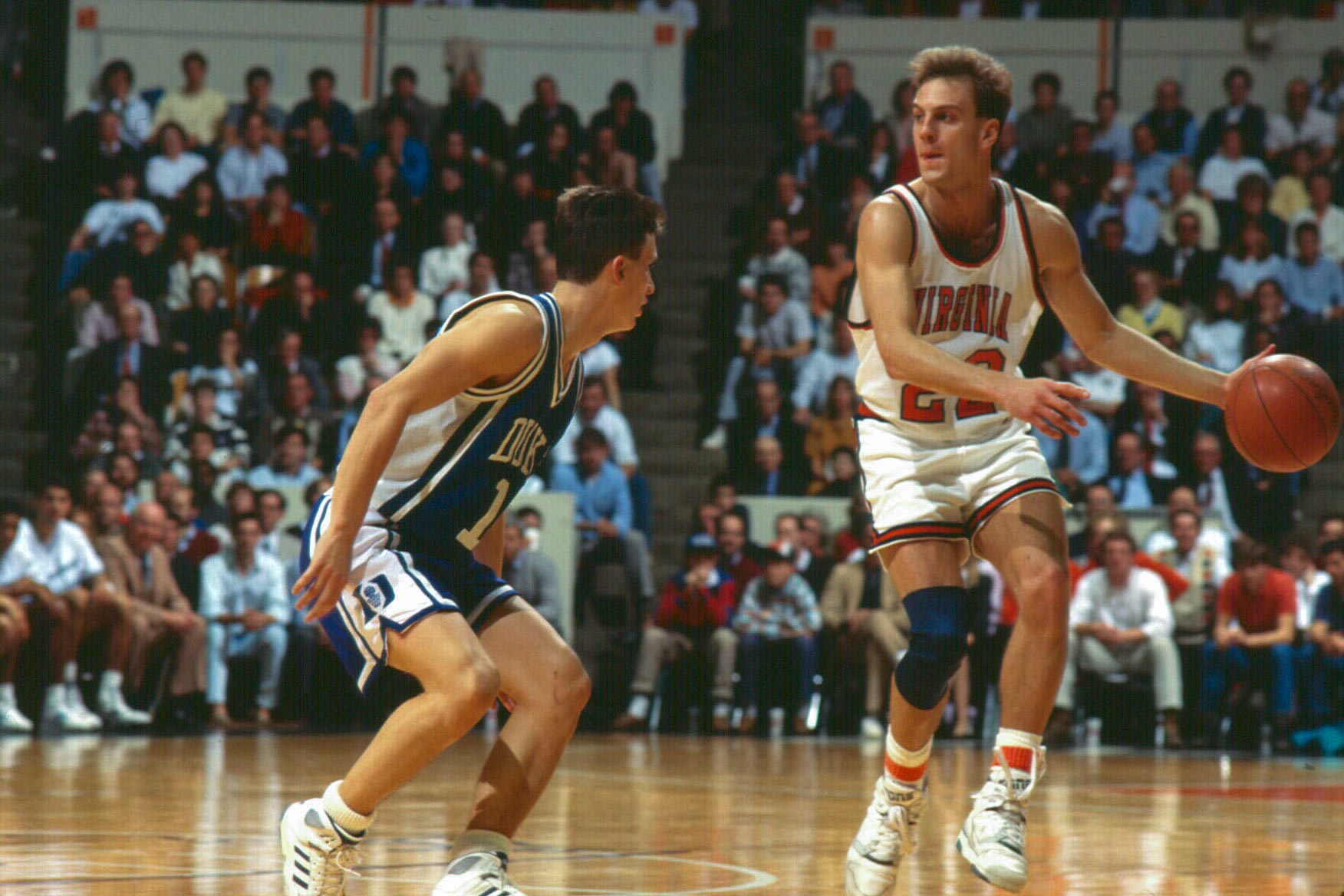 John Crotty in a UVA basketball uniform dribbling the ball during a game