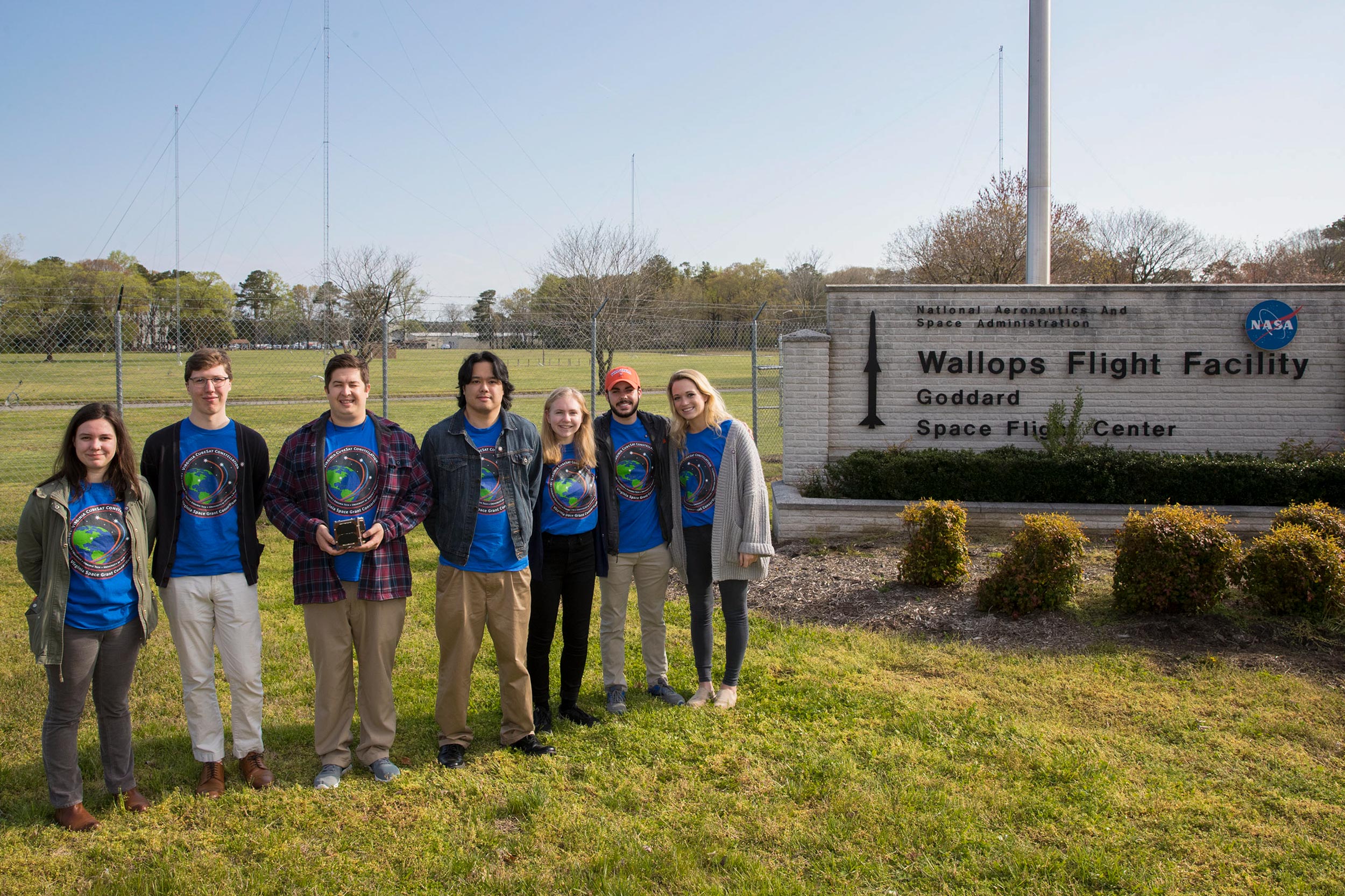 Group stands in front of the Wallops Flight Facility in Virginia for a photo. left to right: Erin Puckette, Wyatt Wilson, Trace LaCour, Justin Javier, Hannah Umansky, Connor Segal and Kathryn Wason
