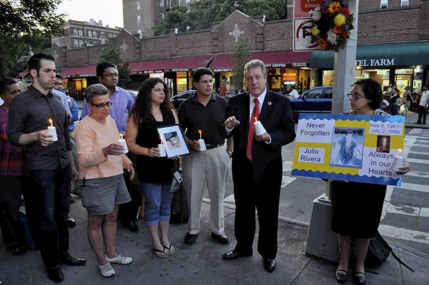 People gather with City Council Member Daniel Dromm with candles to remember Julio Rivera