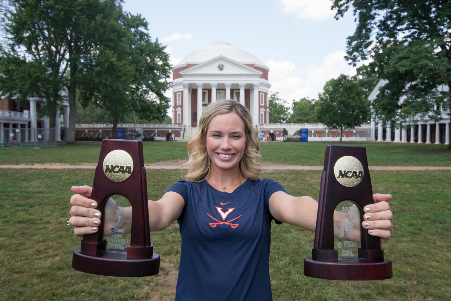 Collins holds  NCAA trophies on the lawn
