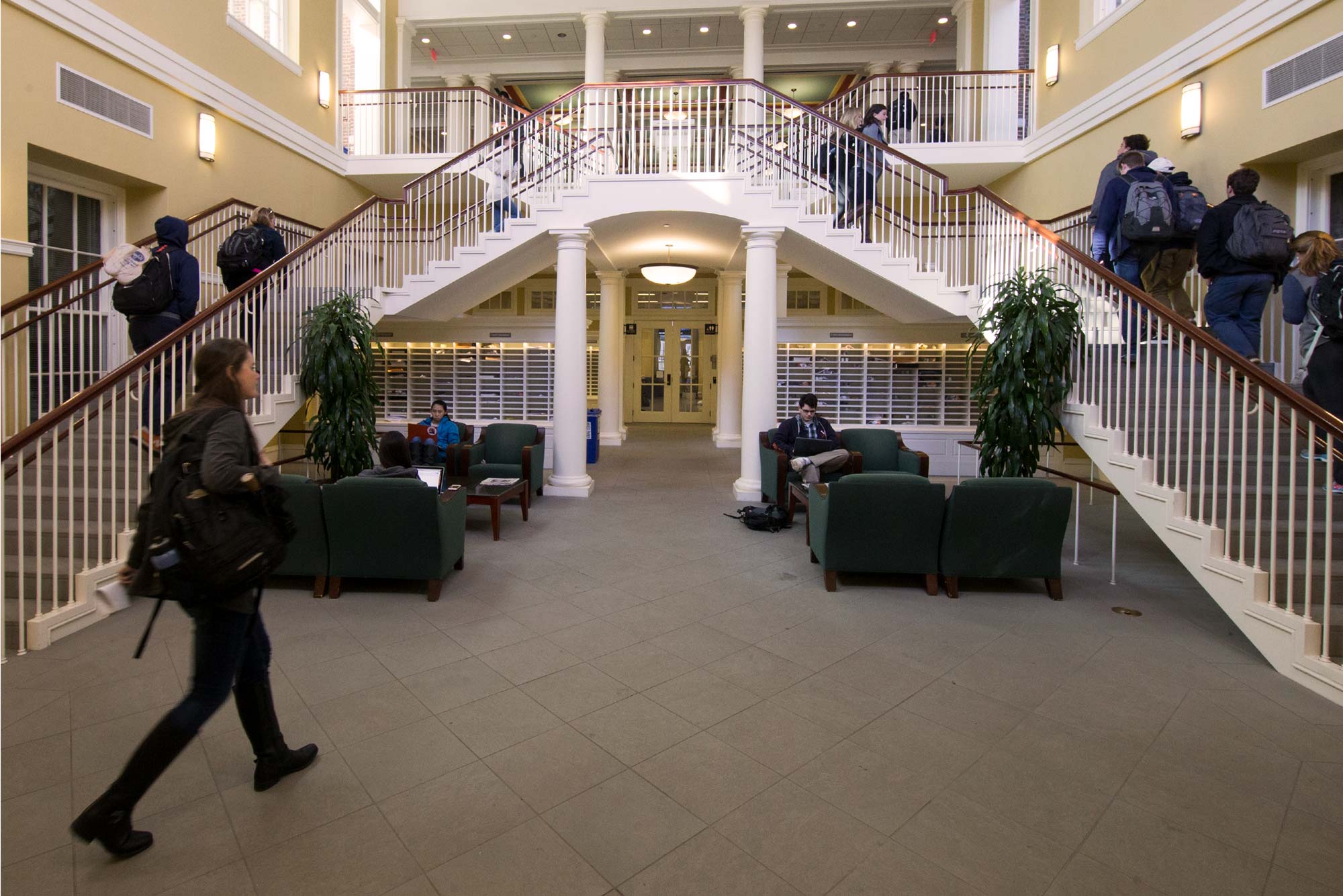 Students walk a hallway and steps in a building