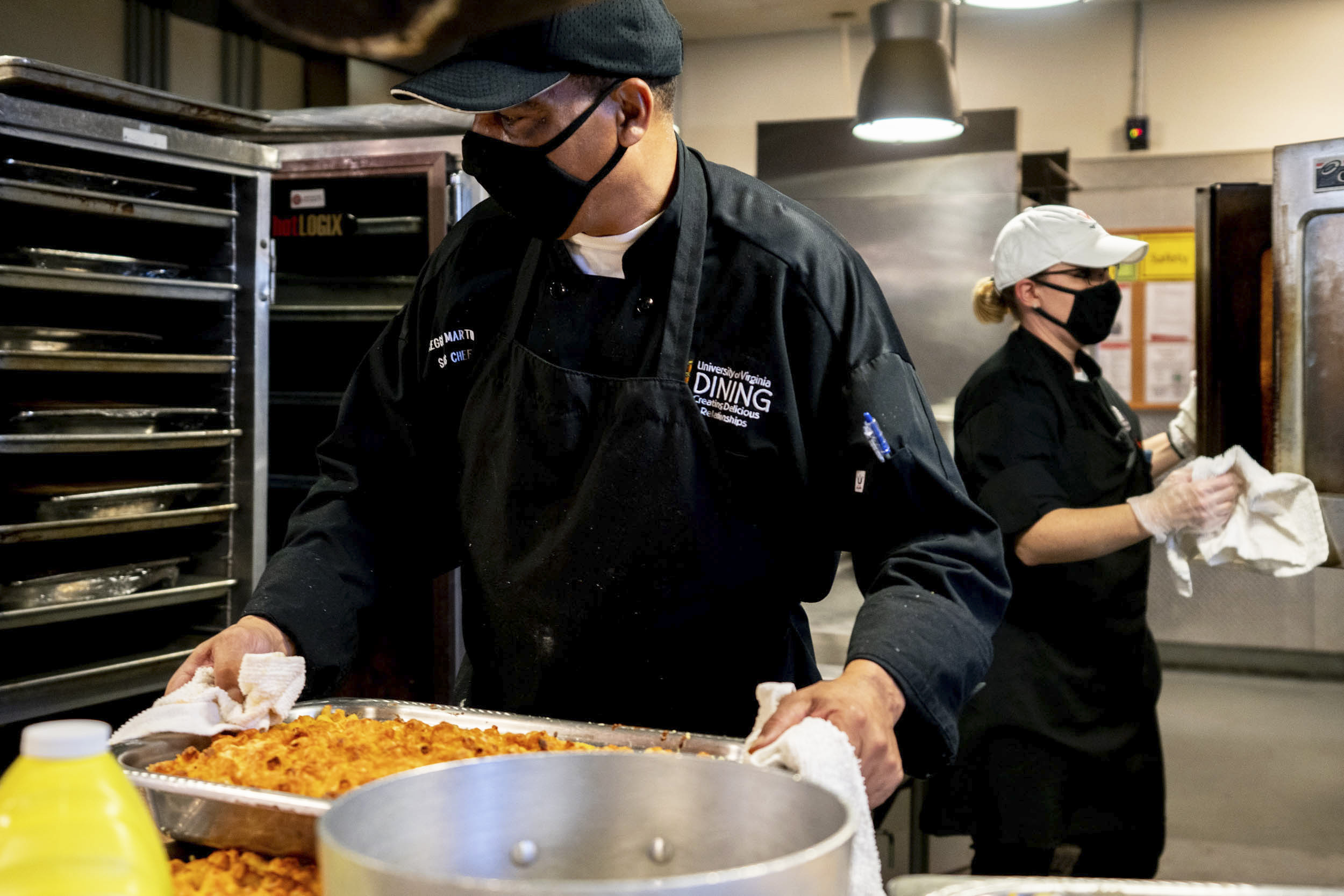 Food Service Workers preparing macaroni and cheese in large platters