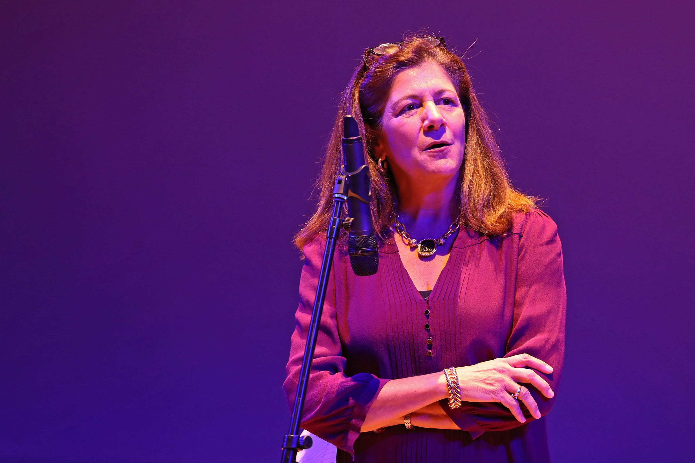 Woman standing at a microphone on a stage