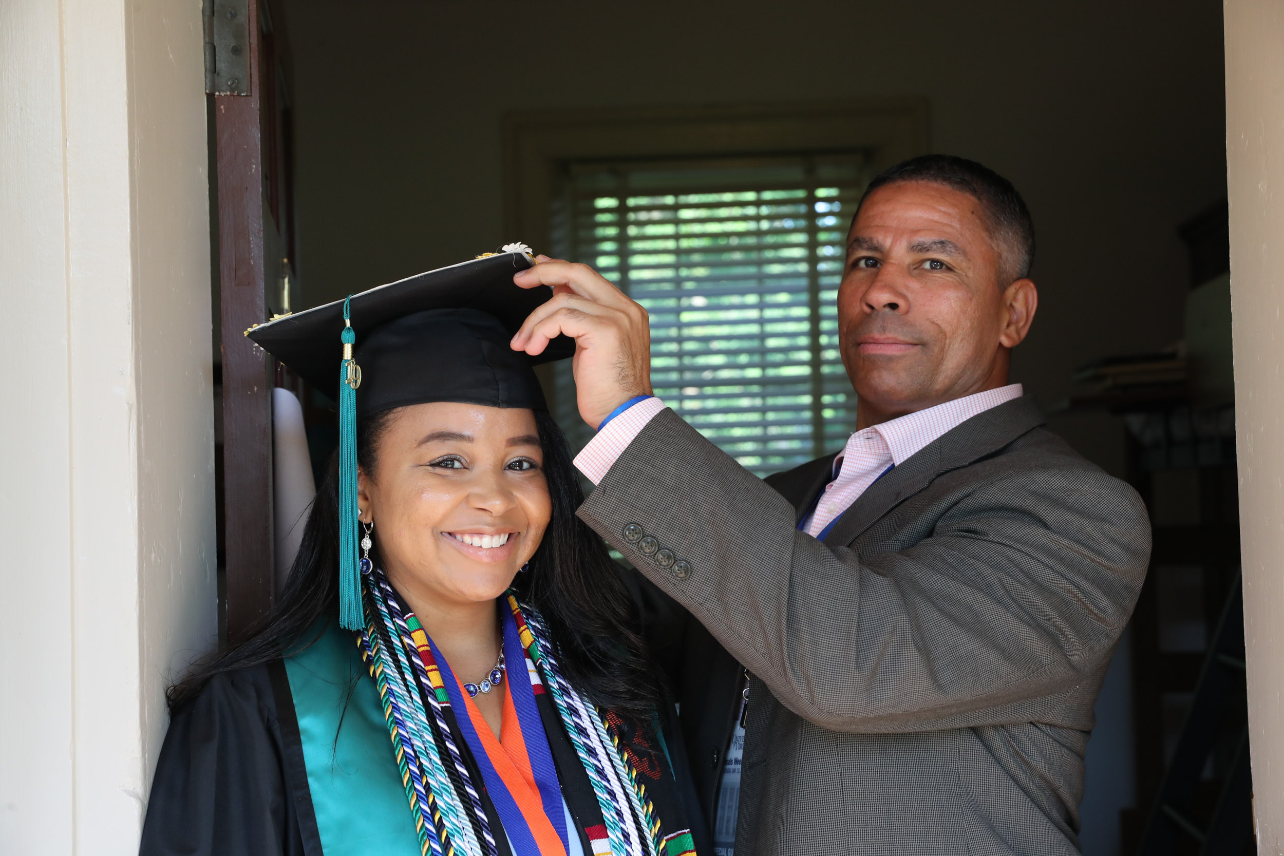 Dad placing his daughters graduation cap on her head